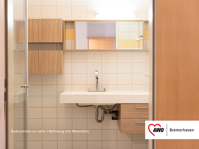 Modernes Badezimmer mit weißem Waschbecken und Holzschränken | © AWO Bremerhaven